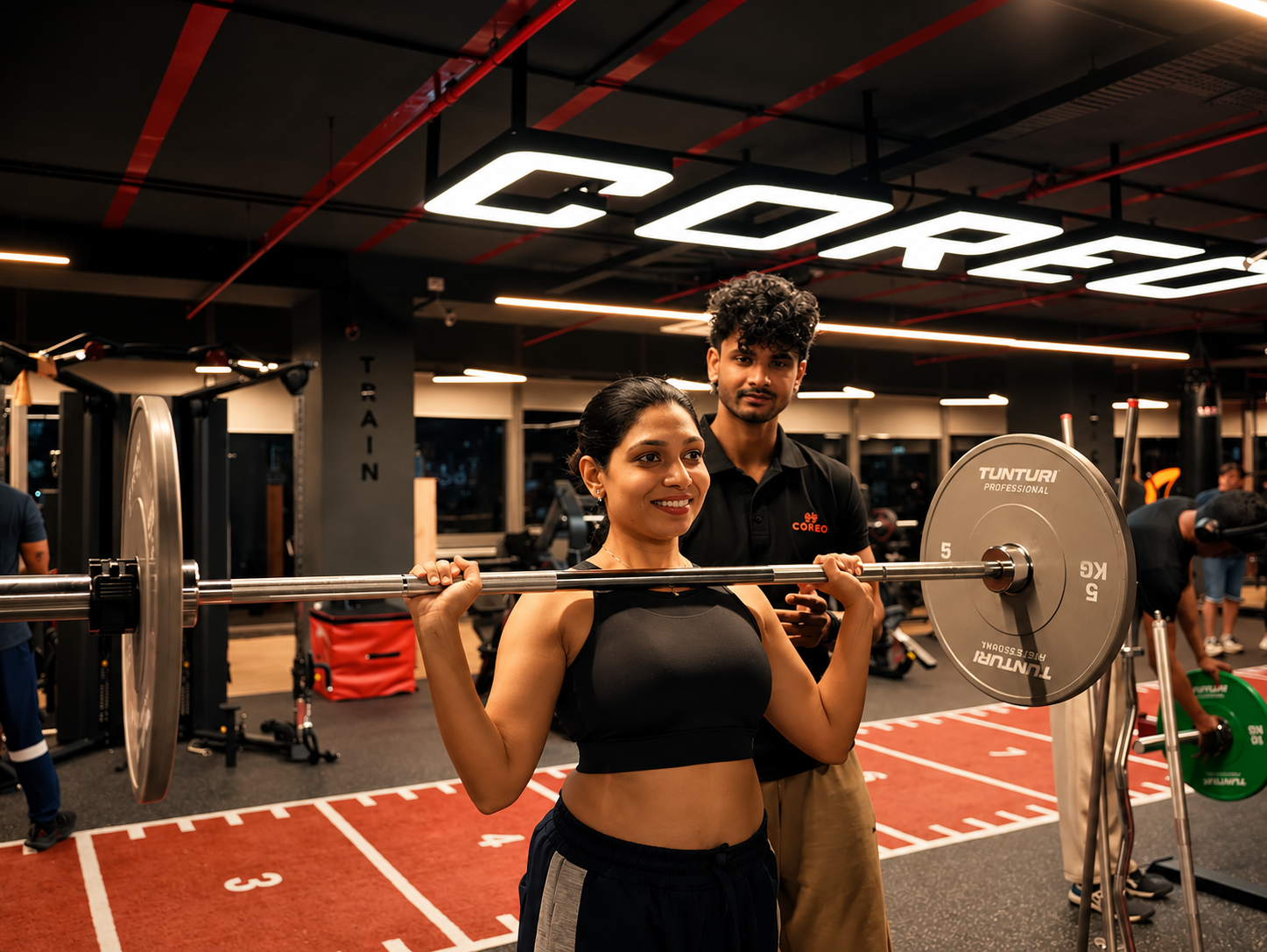 COREO coach guiding a member through a barbell exercise