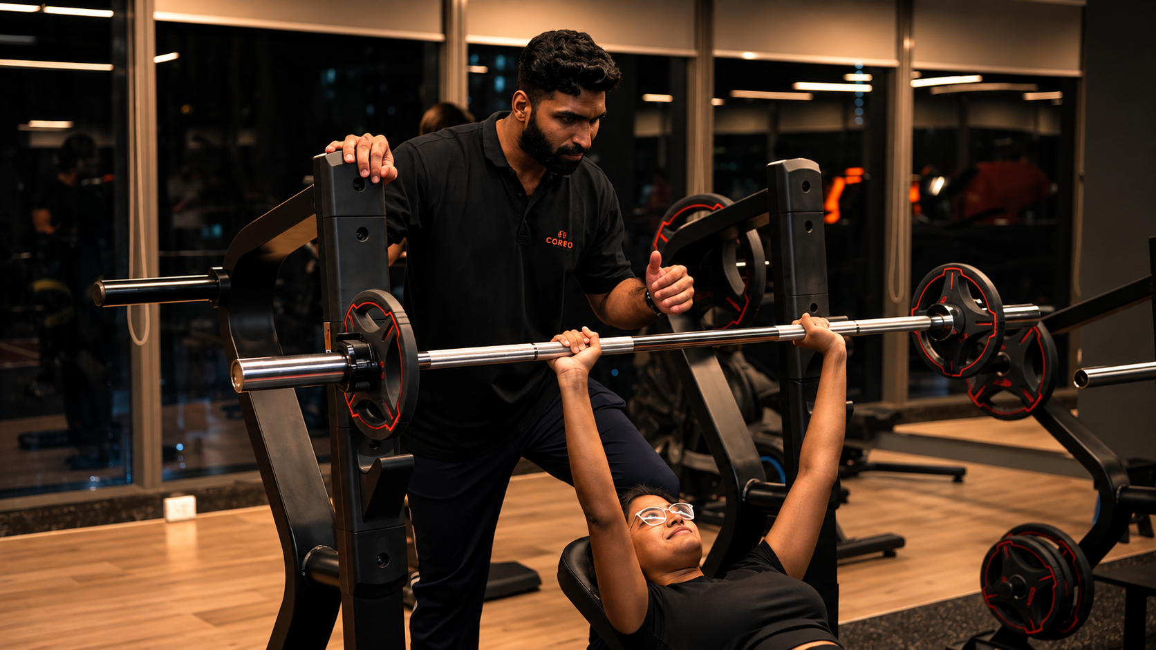 COREO coach spotting a member during a bench press