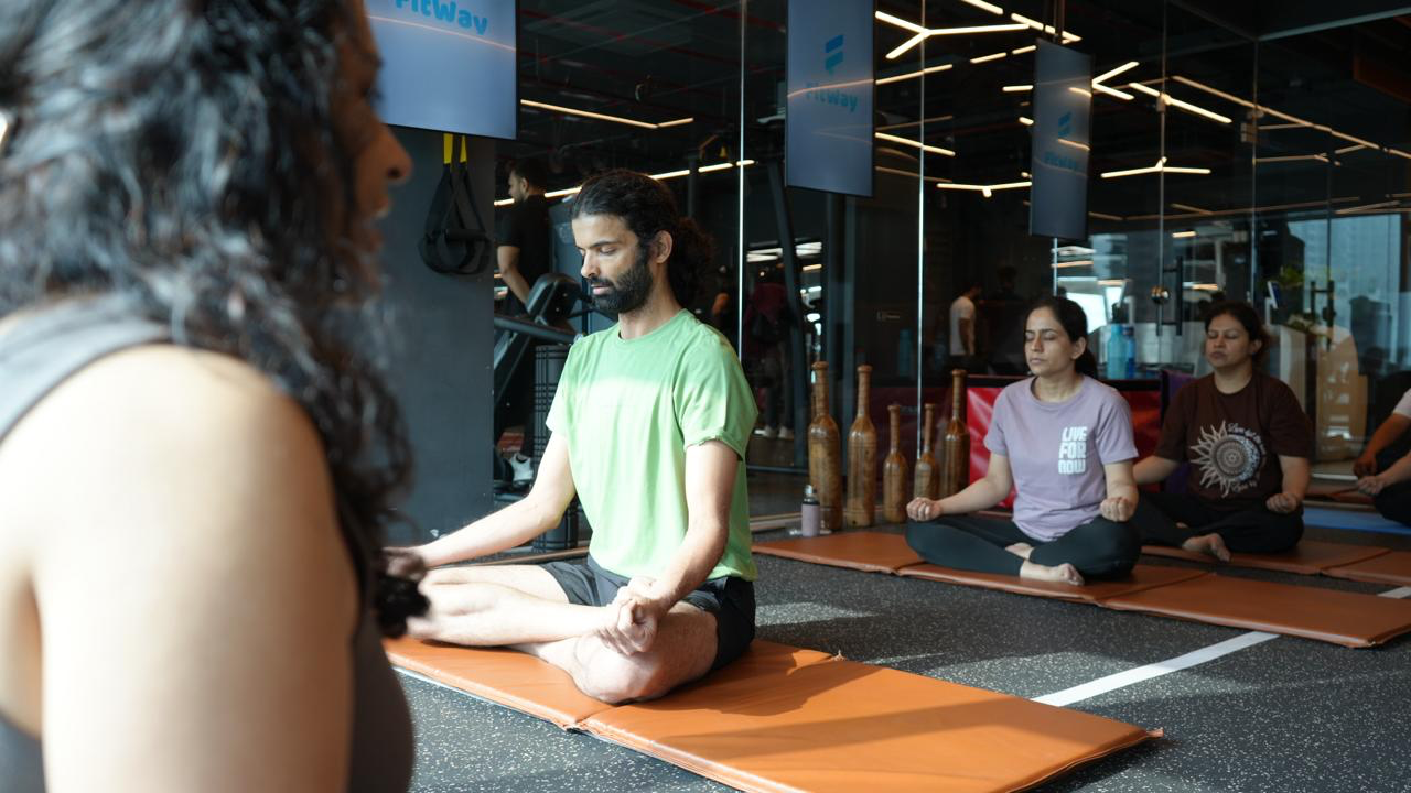 Members seated on yoga mats during a guided class
